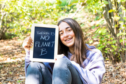 There is no planet B. Young teenager girl with blackboard in a forest. A more sustainable environment for a better planet.