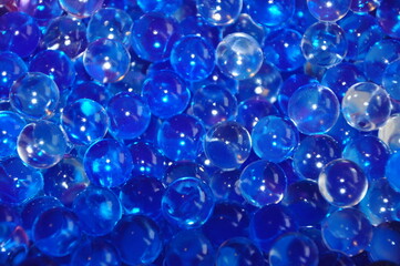 Navy blue water gel bubbles balls background.Transparent blue hydrogel balls. Blue water gel balls with bokeh. Polymer gel Silica gel. Liquid crystal ball with reflection.