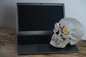 mockup screen, human skull on a laptop keyboard, metal bitcoins in the eye sockets, the concept of...