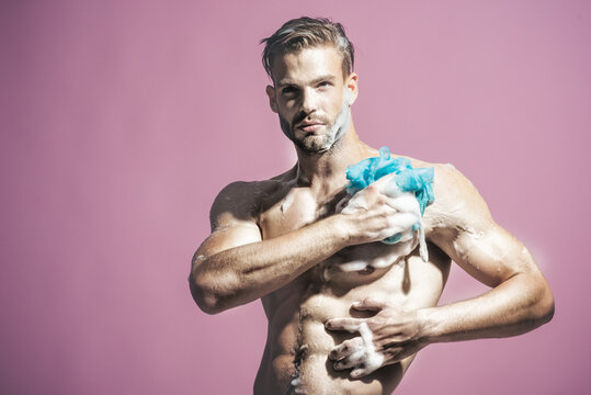 Fitness handsome man taking shower in morning. Muscular fitness bodybuilder taking shower after training. Man washing body in shower. Sexy man washing in bathroom. Naked man taking shower with foam.