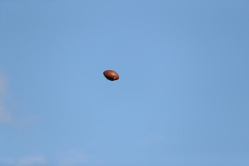 A football is descending to the ground as a high school team warms up prior to a game.