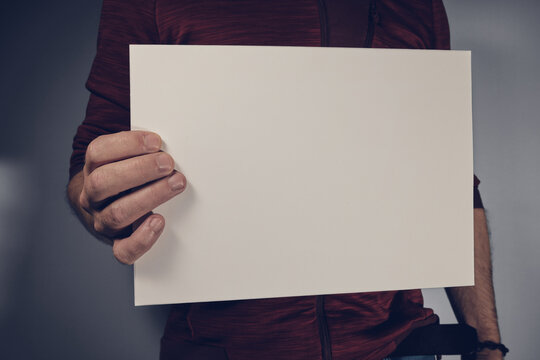 Man holding sheet of paper in the hand