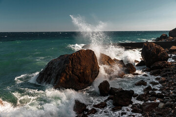 Strengthening the shore from erosion with concrete tetrapods. The seashore with concrete blocks. The element of water. Waves break on concrete.