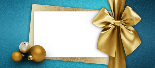 merry christmas gift card, white ticket with golden shiny ribbon bow and xmas balls top view on...