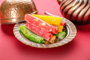 Plate with tasty Turkish delight on color background