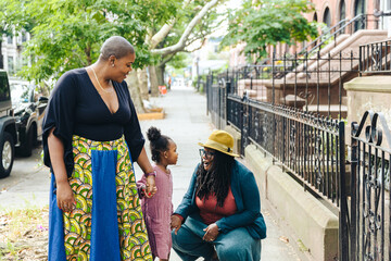 Lesbian woman talking with daughter Holding hand of mother on sidewalk in Brooklyn