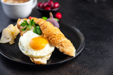 fried egg breakfast croissant, vegetables salad tomato, cucumber ready to eat meal snack on the table copy space food background rustic keto or paleo diet veggie vegetarian food 