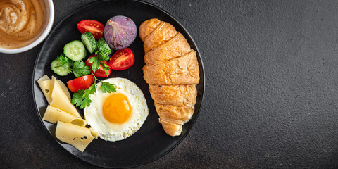 fried egg breakfast croissant, vegetables salad tomato, cucumber ready to eat meal snack on the table copy space food background rustic keto or paleo diet veggie vegetarian food 