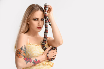 Sexy young woman with snake on white background