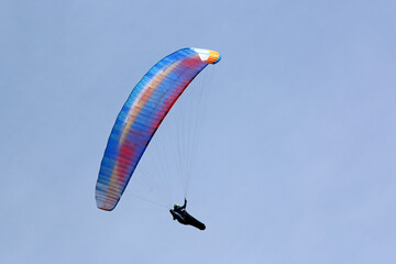 Paraglider in a blue sky	
