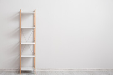 Stylish shelf unit near white wall