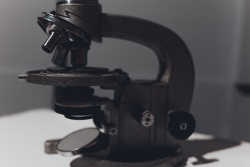 microscope for studying microbes and viruses against a gray three-dimensional wall. concept: photo wallpapers for scientific articles and publications about coronavirus and pandemic.