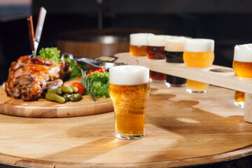 A light craft beer at the table, with other beers and snaks at the background