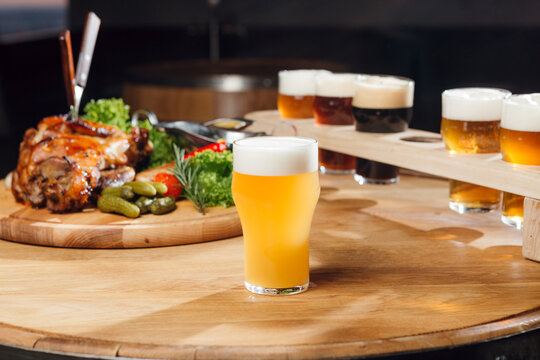 A light unfiltered craft beer at the table, with other beers and snaks at the background