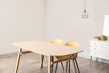 Modern table and chairs in interior of light room