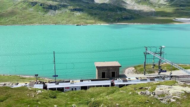 The red UNESCO train arriving at the Bernina Pass station in Switzerland