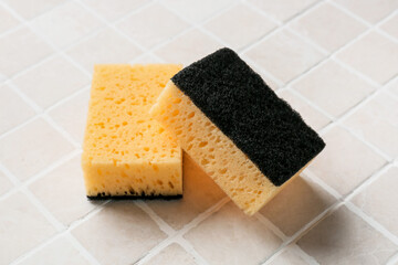 Yellow cleaning sponges on tile background