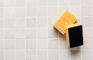 Yellow cleaning sponges on tile background