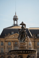 Fototapeta na wymiar Statues of the fountain and facade of the stock exchange in Bordeaux, France