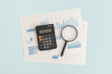 Business graphs, charts, magnifying glass and calculator on table. Financial development, Banking...