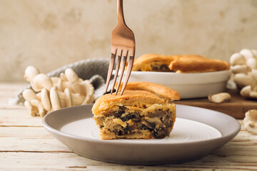 Plate with piece of tasty mushroom pot pie on table