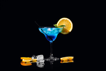 Glass of Blue Lagoon cocktail on dark background