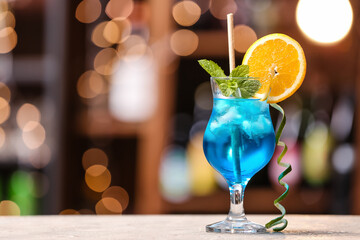 Glass of Blue Lagoon cocktail on table in bar