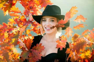 Portrait of cheerful young woman with autumn leafs. Autumn woman with yellow maple leaves on golden fall. Happy smiling young woman in park on sunny autumn day outdoors on beautiful fall day.