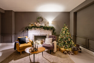 Classic apartments with decorated christmas tree and presents. Christmas evening in the light of candles and garlands. Living with fireplace and stucco.