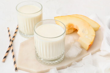 Glasses of tasty melon milkshake on light background, closeup