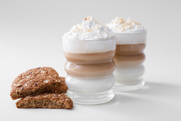 Fototapeta na wymiar Glasses of tasty latte with nuts on light background