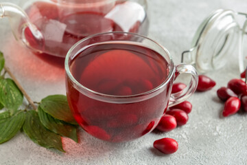 Cup of healthy dogwood berry drink on grey background © Pixel-Shot