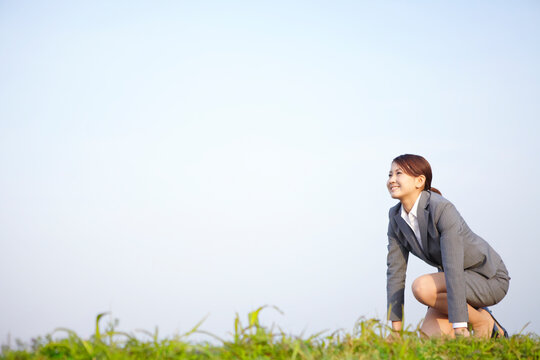 クラウチングスタートをするビジネスウーマン