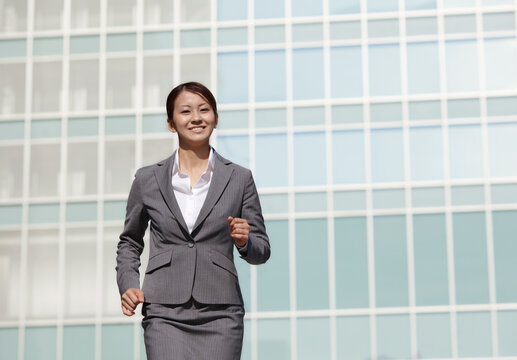 ビジネス街を走るフレッシュなビジネスウーマン