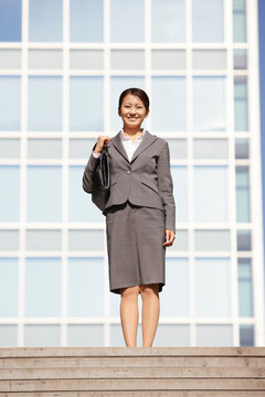 ビジネス街で正面を見るフレッシュなビジネスウーマン