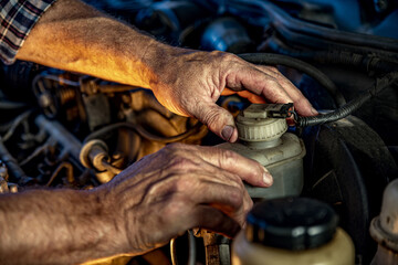 Repairman's male hands with a wrench. Vehicle fitter inspecting used car engine