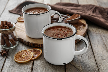 Cups of tasty hot chocolate on wooden background