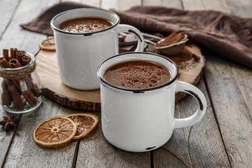 Fotobehang Cups of tasty hot chocolate on wooden background © Pixel-Shot