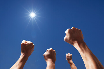 太陽に向かって強く突き上げられた4本の腕