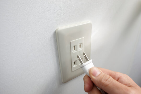 白いプラグを抜く手