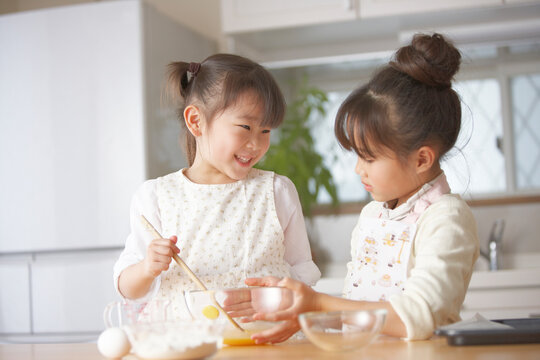 台所でパン作りをする姉妹