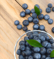blue berry in glass bowl on wooden board