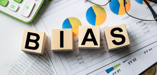 The inscription on the cubes, the word BIAS on the cubes of wooden texture. View from above. Desktop with documents. An inscription on a financial, business or economic theme.