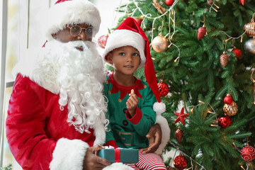 Fototapeta na wymiar Santa Claus with little African-American boy at home