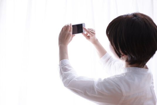 携帯電話を持って写真を撮る女性の手