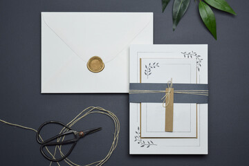 Modern wedding invitation blank flat lay mock-ups. Wedding stationery includes invitation, rsvp, save the date, envelopes, wax seal and stamp. Customize an empty clean design on black background. 