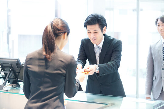 受付にて名刺を受けとる受付の女性