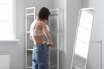 Fototapeta na wymiar Young skinny woman in front of mirror at home. Anorexia concept