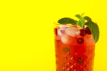 Glass with tasty cranberry juice on color background