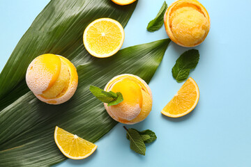 Tasty ice creams in orange peels on color background